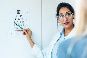 Optometrist showing eye test chart to patient