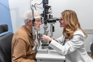 A patient is getting an eye exam from an optometrist