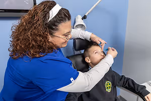 A female dentist examining a child's teeth in a dental clinic.