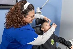 A female dentist examining a child's teeth in a dental clinic.