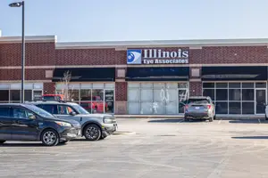 The Illinois Eye Associates building is visible in front of a parking lot with a few cars parked on the side.