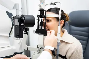 A woman undergoing an eye examination in a clinic with a camera focused on her eye.