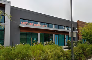 Exterior of the Saratoga Vision Center building with glass windows and a wooden awning.