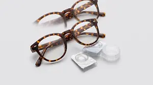 A pair of brown and tortoiseshell-framed glasses with a pair of contact lenses on a white background