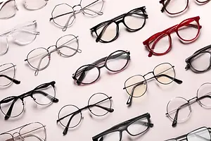 A collection of glasses with different colored frames and lenses displayed on a white surface.