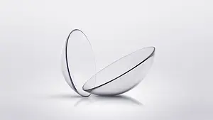 A close-up of two contact lenses placed on a white surface
