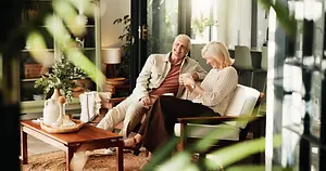 A man and woman sitting on a chair and enjoying coffee