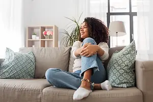 A woman sitting on a couch smiling at the camera