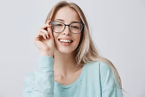 Woman wearing glasses and a blue shirt smiling for a photo