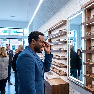 a man is trying on glasses in an optics shop