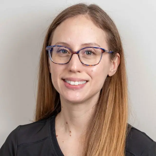 Headshot of a woman with glasses smiling at the camera