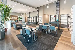 A modern and well-lit interior of an optical shop with various furniture and decorations.