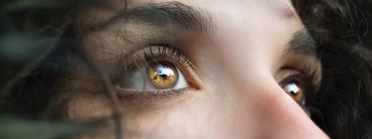 Close up of a woman with brown eyes and eyelashes looking at something