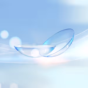 Two transparent contact lenses on a blue background
