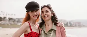 Two women on a beach smiling at the camera