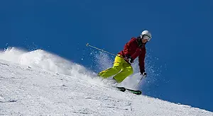 A person skiing down a snowy slope on a sunny day