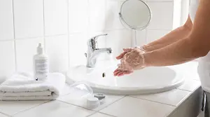 A person is washing their hands in a sink in a bathroom