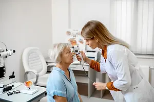 A woman is getting her eyes checked by an optometrist in an optical clinic