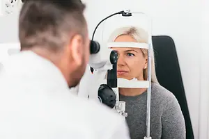 Eye doctor examining a female patient with a slit lamp