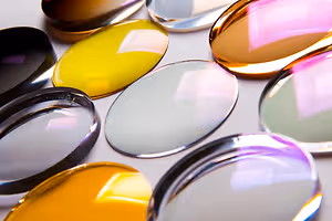 Many multi-colored glass objects are arranged on a white surface.