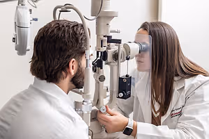 Optometrist checking a man's eyes with a slit lamp.