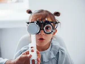 A young girl is getting her vision checked at an optometrist.