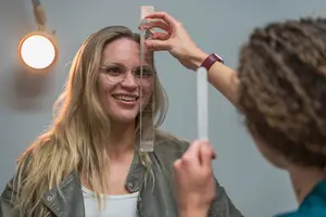 Woman smiling while having her eyes checked by a doctor