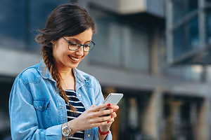 Happy woman looking at her phone while smiling