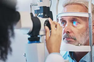 A man is getting an eye exam with a doctor in a room