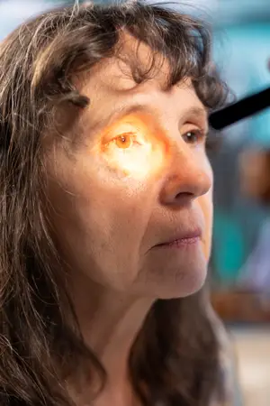 Close up of woman's eye with bright light illuminating iris