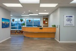An indoor area with a reception desk and windows overlooking the city