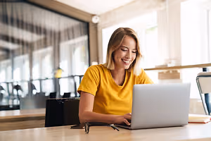 A woman working on a laptop in a cafe