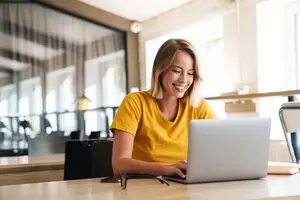 A woman working on a laptop in a cafe