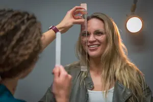 Woman with glasses being examined by a professional in an optical clinic