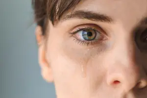 A close up of a woman's face with tears on her cheeks