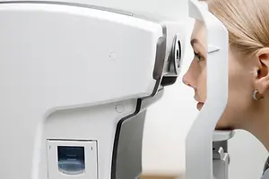 woman in an eye clinic looking into a machine