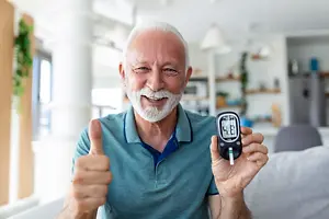 An elderly man checking his blood sugar levels