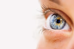 Close up of a woman's eye with a reflection of a white background in the pupil