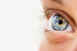 Close up of a woman's eye with a reflection of a white background in the pupil