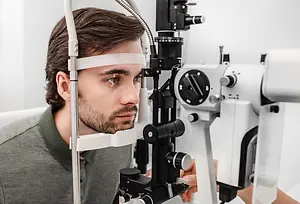A man getting his eye tested at the optometrist's office.