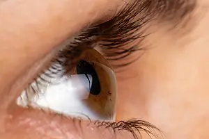 Close-up of a person's eye with eyelashes, cornea, and iris visible