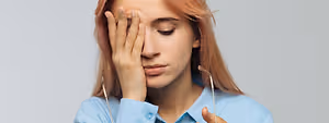 A woman is feeling stressed and holding her head in her hands.