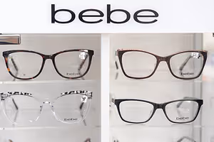A white display case with Bebe brand glasses on it.