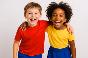 Two children, a boy and a girl, are smiling and standing close to each other with their arms around each other.