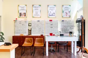 Inside of an optometrist's office at Warden Optometry in Markham, ON, with chairs, a table, and displays of eyeglasses.