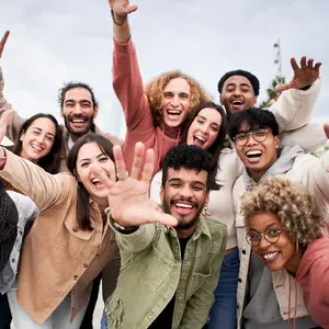 A group of people in different colors are smiling and posing for a photo in an outdoor area.