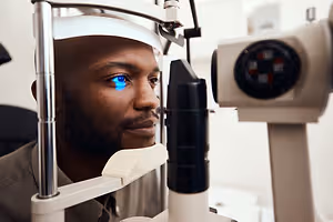 A man is having his eyes examined by an eye doctor using a medical instrument