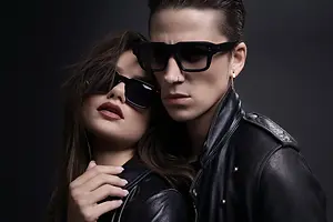 A woman and man wearing sunglasses and black leather jackets pose for a photo