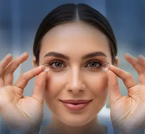 Woman holding contact lenses and smiling