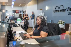 A woman is typing on a computer at the Greenway Vision store.